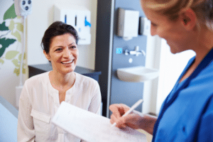 doctor writing something down while patient is smiling