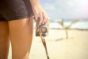 woman on beach holding camera